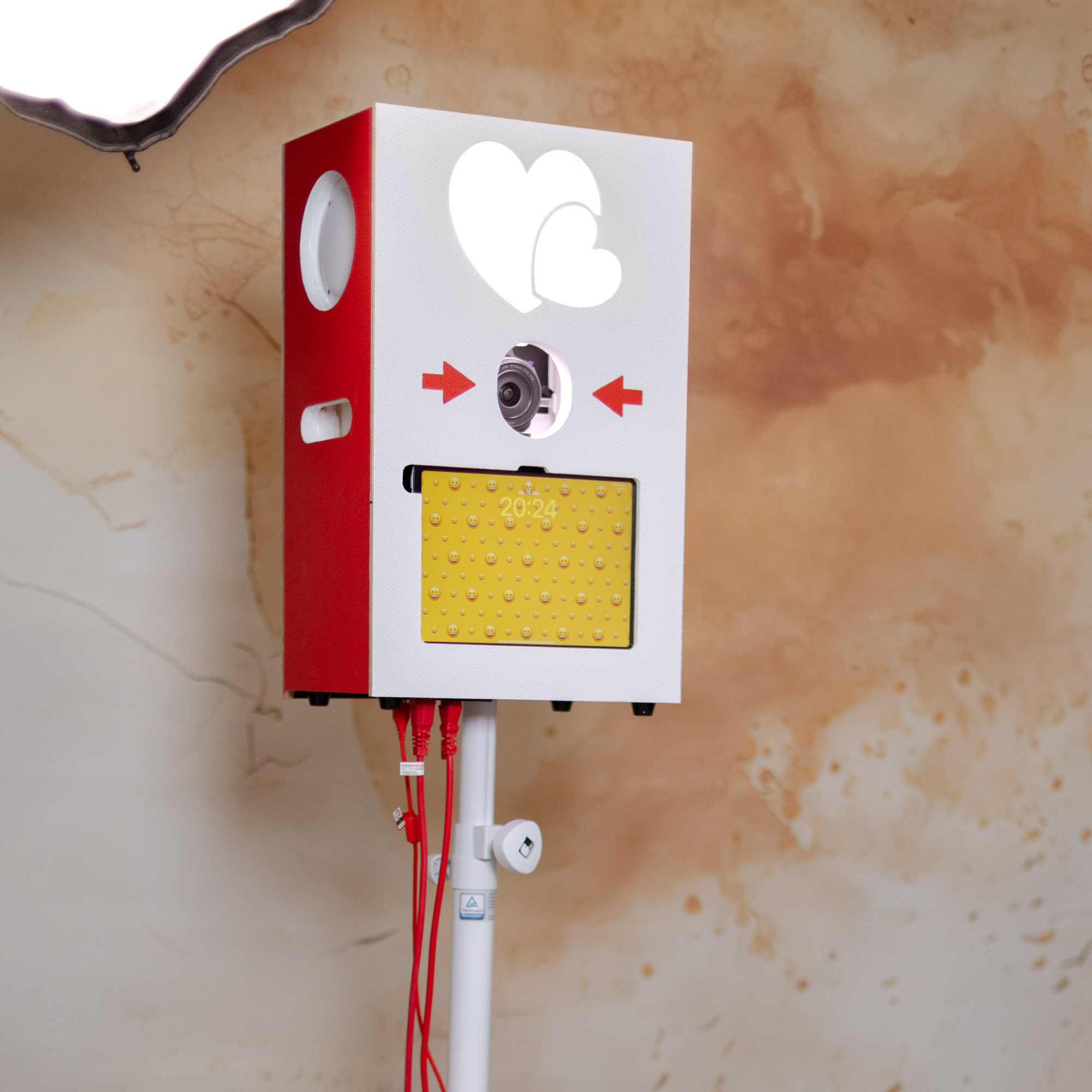 Fertig gebaute Fotobox in Rot und Weiß mit LED-Herzen auf dem Stativ